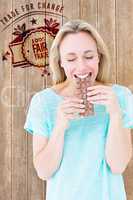 Composite image of happy blonde eating bar of chocolate