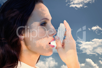 Composite image of asthmatic brunette using her inhaler