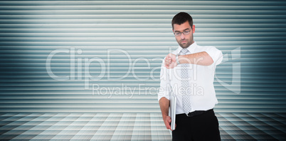 Composite image of serious businessman holding laptop checking t