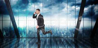 Composite image of businessman running on the phone