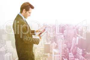 Composite image of businessman standing while using a tablet pc