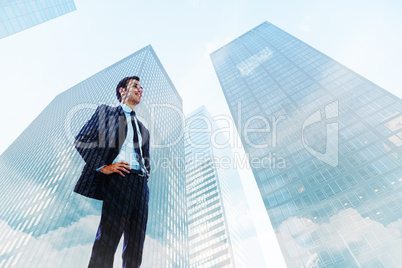 Composite image of happy businessman with hands on hips