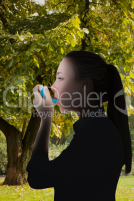 Composite image of beautiful blonde using an asthma inhaler