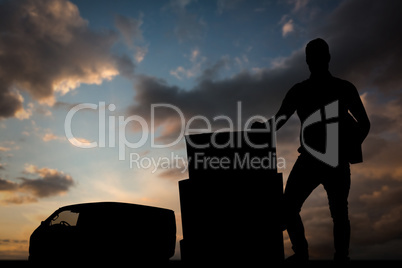 Composite image of courier man with cardboard boxes