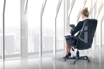 Composite image of businesswoman sitting on swivel chair with ta