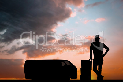 Composite image of happy delivery man leaning on trolley of boxe