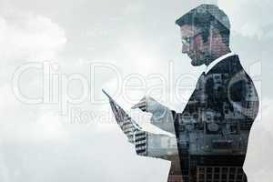 Composite image of mid section of a businessman touching tablet