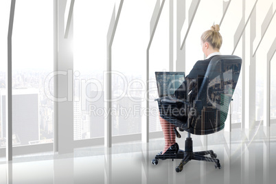 Composite image of businesswoman sitting on swivel chair with la