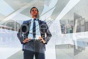 Composite image of serious businessman with hands on hips