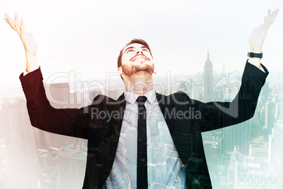 Composite image of businessman cheering with hands raised