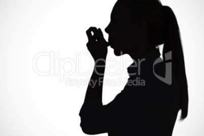 Composite image of beautiful blonde using an asthma inhaler