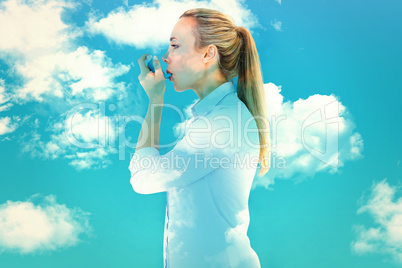 Composite image of beautiful blonde using an asthma inhaler