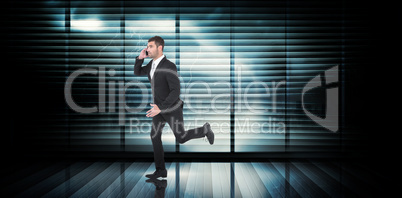 Composite image of businessman running on the phone