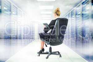 Composite image of businesswoman sitting on swivel chair with ta