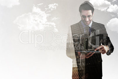 Composite image of businessman standing while using a tablet pc