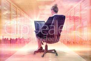 Composite image of businesswoman sitting on swivel chair with la