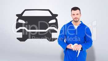 Composite image of mechanic wiping hands with cloth