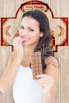 Composite image of pretty brunette fearfully looking at chocolat