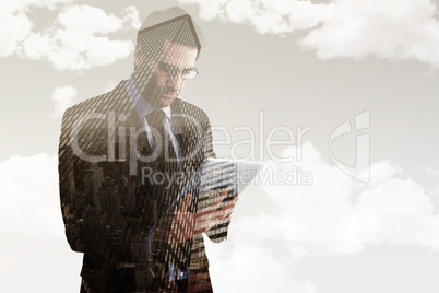 Composite image of businessman using a tablet computer