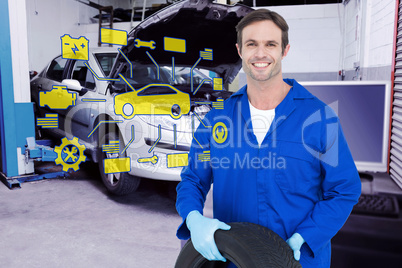 Composite image of confident mechanic holding tire