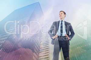 Composite image of happy businessman with hands on hips