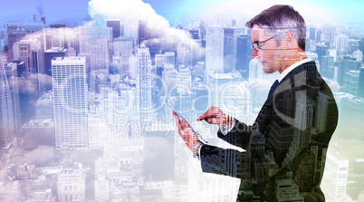 Composite image of mid section of a businessman touching tablet