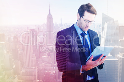 Composite image of businessman using a tablet computer