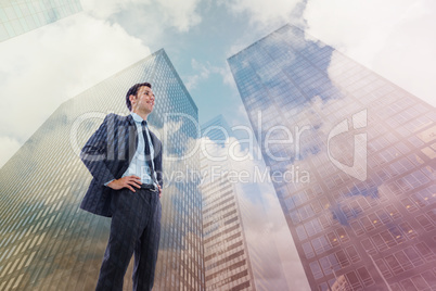 Composite image of happy businessman with hands on hips