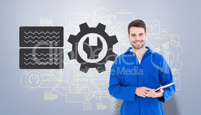 Composite image of happy young male mechanic using digital table