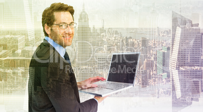 Composite image of smiling businessman using a laptop