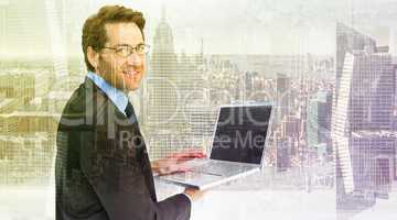 Composite image of smiling businessman using a laptop