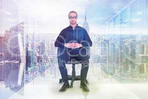 Composite image of stern businessman sitting on an office chair