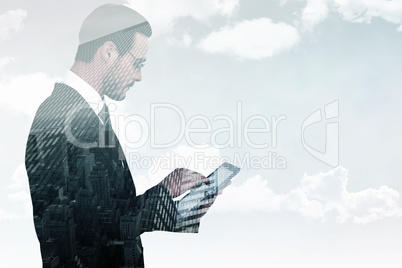 Composite image of businessman in reading glasses using his tabl