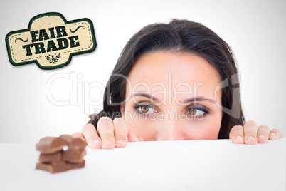 Composite image of pretty brunette peeking at chocolate