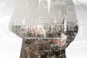 Composite image of businessman using his tablet pc
