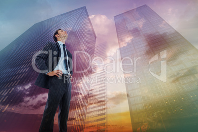 Composite image of serious businessman with hands on hips