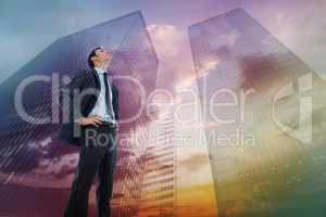 Composite image of serious businessman with hands on hips