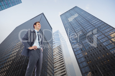 Composite image of happy businessman with hands on hips