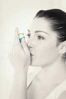 Woman with asthma using an asthma inhaler