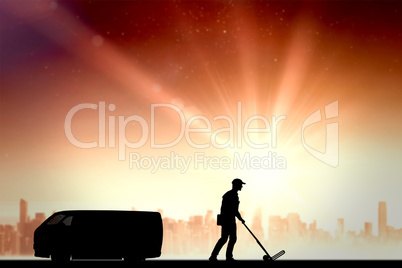 Composite image of delivery man pushing empty trolley