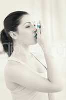 Brunette using asthma inhlaer