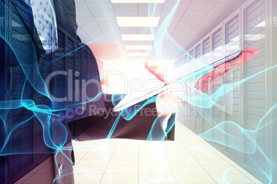 Composite image of businessman using his tablet pc