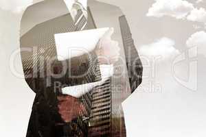 Composite image of businessman holding his laptop tightly