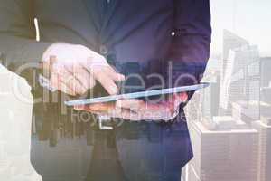 Composite image of mid section of a businessman touching digital