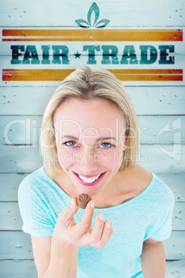 Composite image of smiling blonde holding box of chocolates