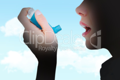 Composite image of close up of a woman using an asthma inhaler Composite image of close up of a woman using an asthma inhaler