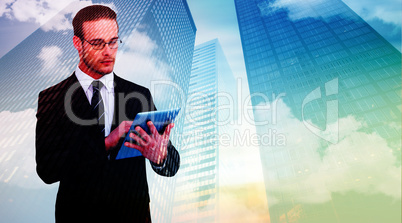 Composite image of unsmiling businessman using tablet pc