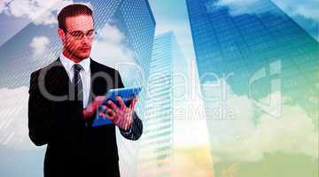 Composite image of unsmiling businessman using tablet pc