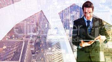 Composite image of businessman standing while using a tablet pc