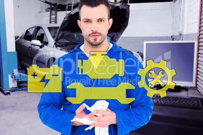 Composite image of mechanic wiping hands with cloth